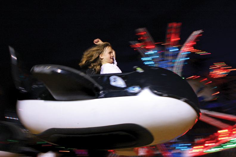 Kori Deaton, 6, throws an arm up while on a whale ride during the Fun Zone Amusements Carnival on Thursday at the Moffat County Fairgrounds. The Craig Chamber of Commerce brought the attraction to town.