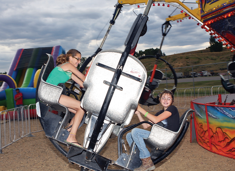 Tina Gereaux, 14, left, and Marissa Butler, 13, spin around on the Tornado ride at the carnival Saturday at the Moffat County Fairgrounds.
