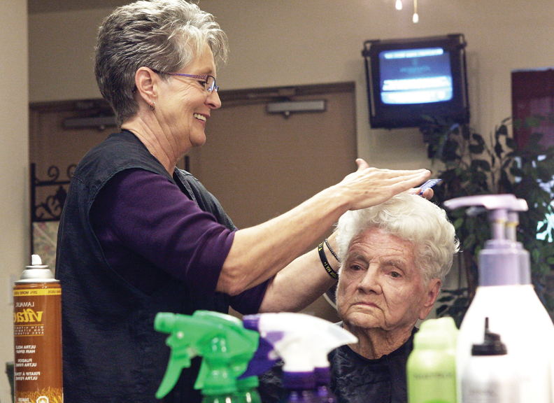 LaDawn Sexton shapes the hair of Vernice Self, 91, on Wednesday in the beauty shop at Sunset Meadows. Sexton offers her services to all ages and sees about 15 to 20 clients a day.