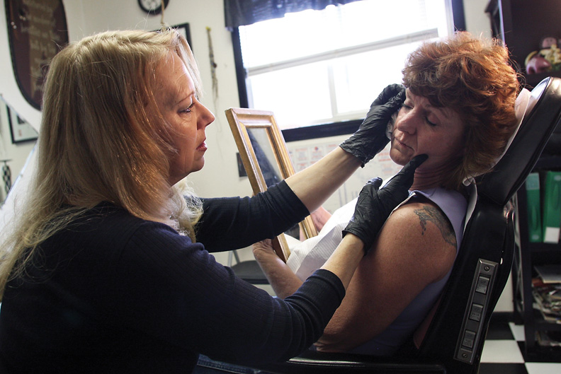 Pam Wilson-Orth checks her work after tattooing permanent eyeliner on Cathy Rogers on April 13. Rogers said she was tired of putting on eyeliner every day and was excited to skip that part of her morning routine.
