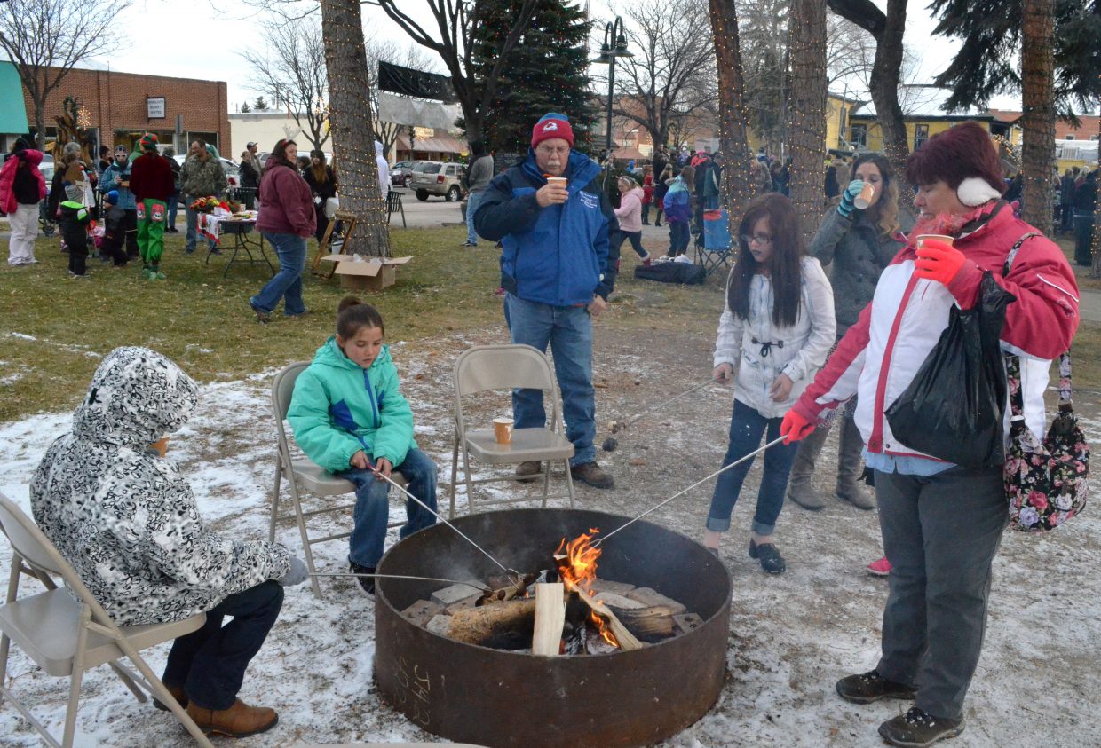 Community members roast chestnuts and marshmallows over a fire pit during Down Home Christmas Celebration Saturday at Alice Pleasant Park.