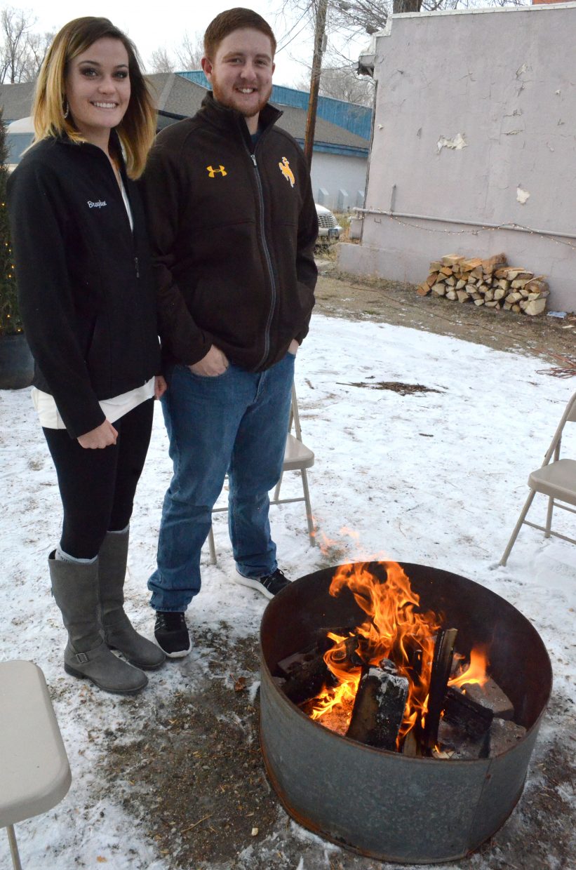Brayden Anderson, left, and Trevor Kuhn warm up next to a fire pit during Down Home Christmas Celebration Saturday at Alice Pleasant Park.