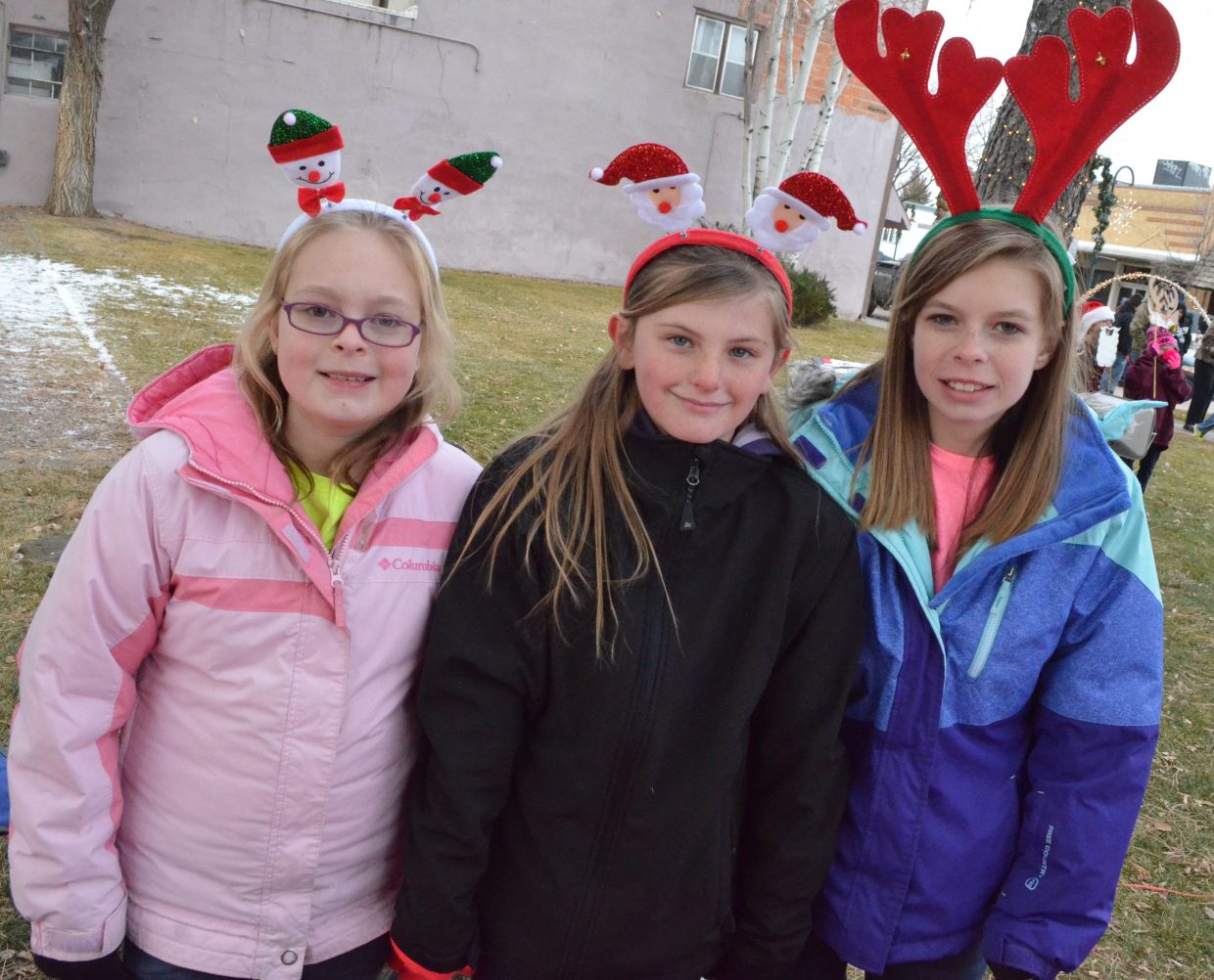 From left, volunteers Teagan Kopsa, Brooklynn Kroese and Kendra Kopsa don unique antlers while running the reindeer food table during Down Home Christmas Celebration Saturday at Alice Pleasant Park.