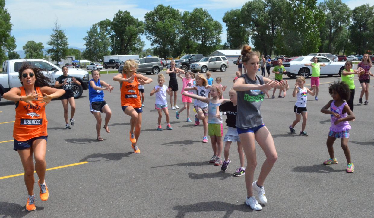 Members of the Denver Broncos cheerleaders work with Craig girls on a routine Saturday at Loudy-Simpson Park as part of the Victory Motors Cancer Drive. Cheerleaders and football players in attendance also provided autographs.