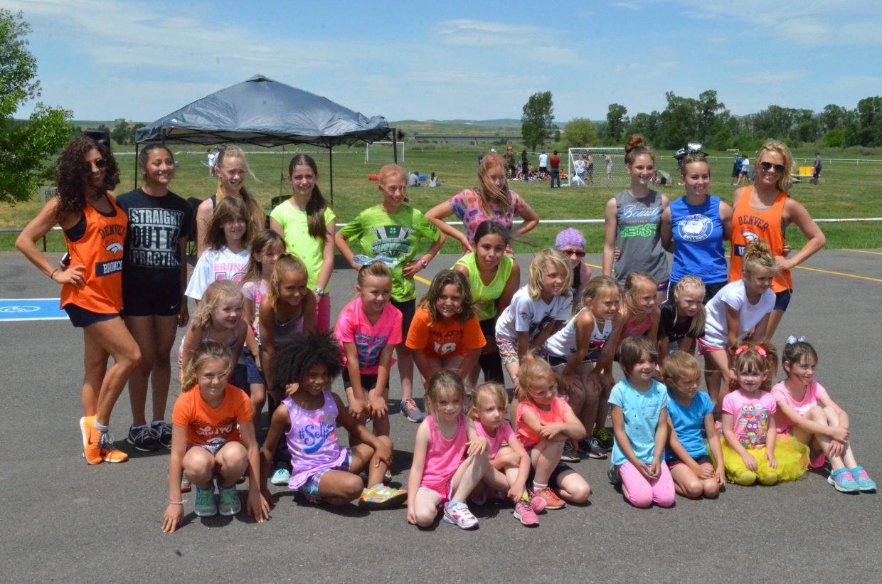 Local cheerleaders pose with members of the Denver Broncos cheer squad Saturday at Loudy-Simpson Park as part of the Victory Motors Cancer Drive.