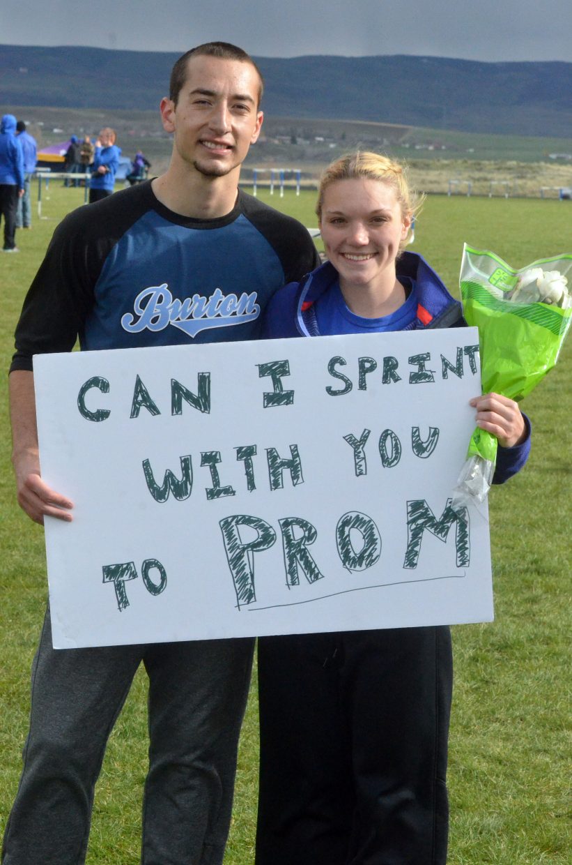 Moffat County High School's Shandon Hadley and Kayla Pinnt hold up a sign Hadley made inviting her to prom during the Clint Wells Invitational. Hadley presented her with the sign and a bouquet at the finish line of the 200-meter dash.