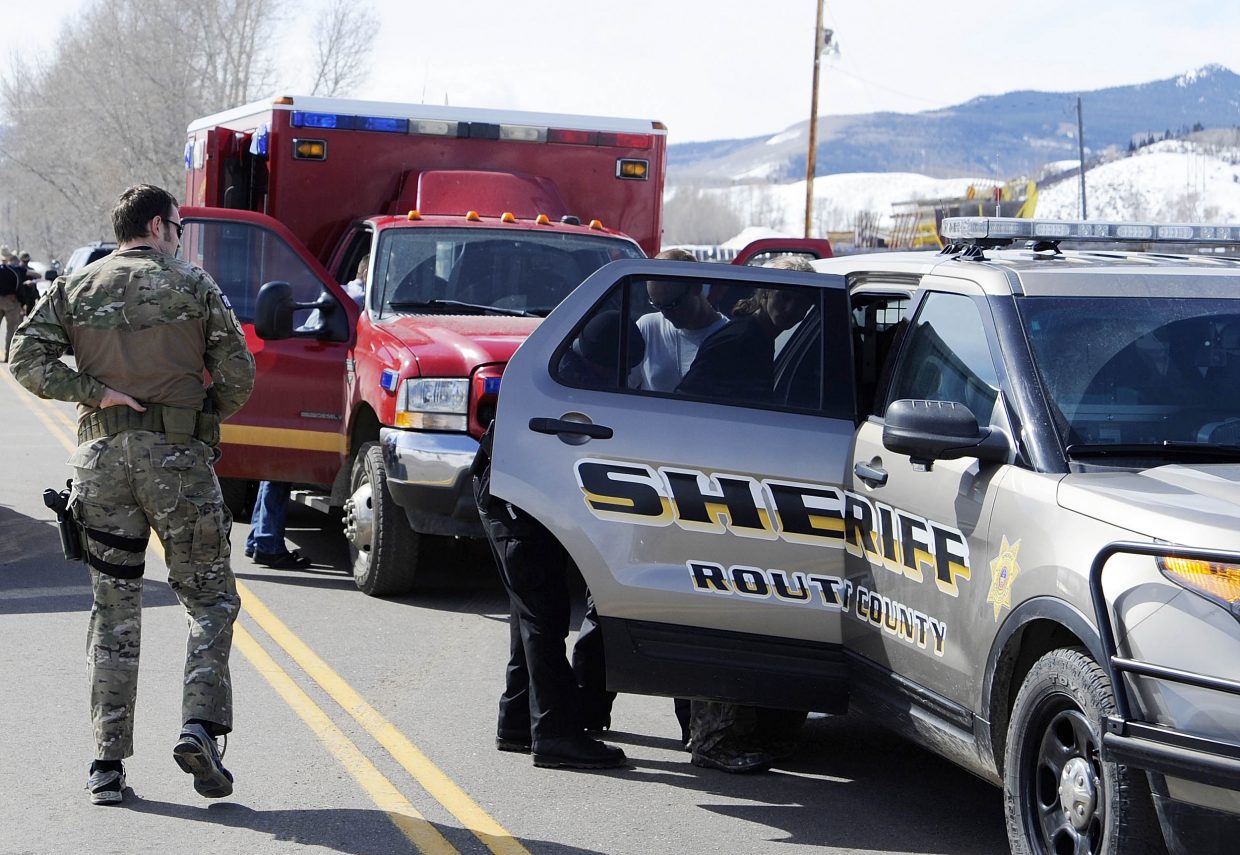 Routt County Sheriff's Office deputies take one of the three juvenile carjacking suspects into custody near Yampa Friday.
