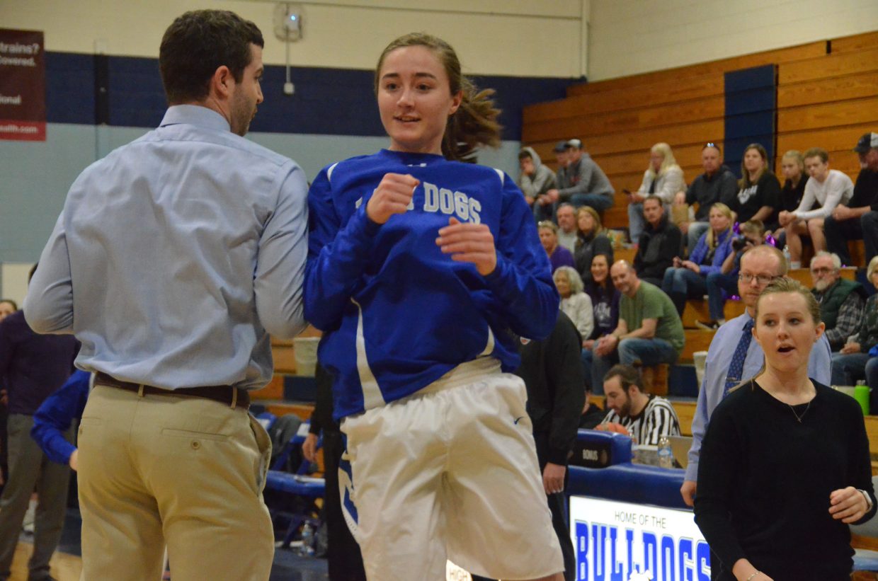 Moffat County High School's Josie Timmer bumps shoulders with assistant coach Joe Padon during pre-game warmups.