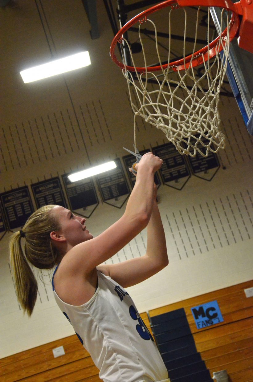 Moffat County High School's Jana Camilletti cuts loose a piece of the home net in the MCHS gym following a regional tournament win against Lutheran.