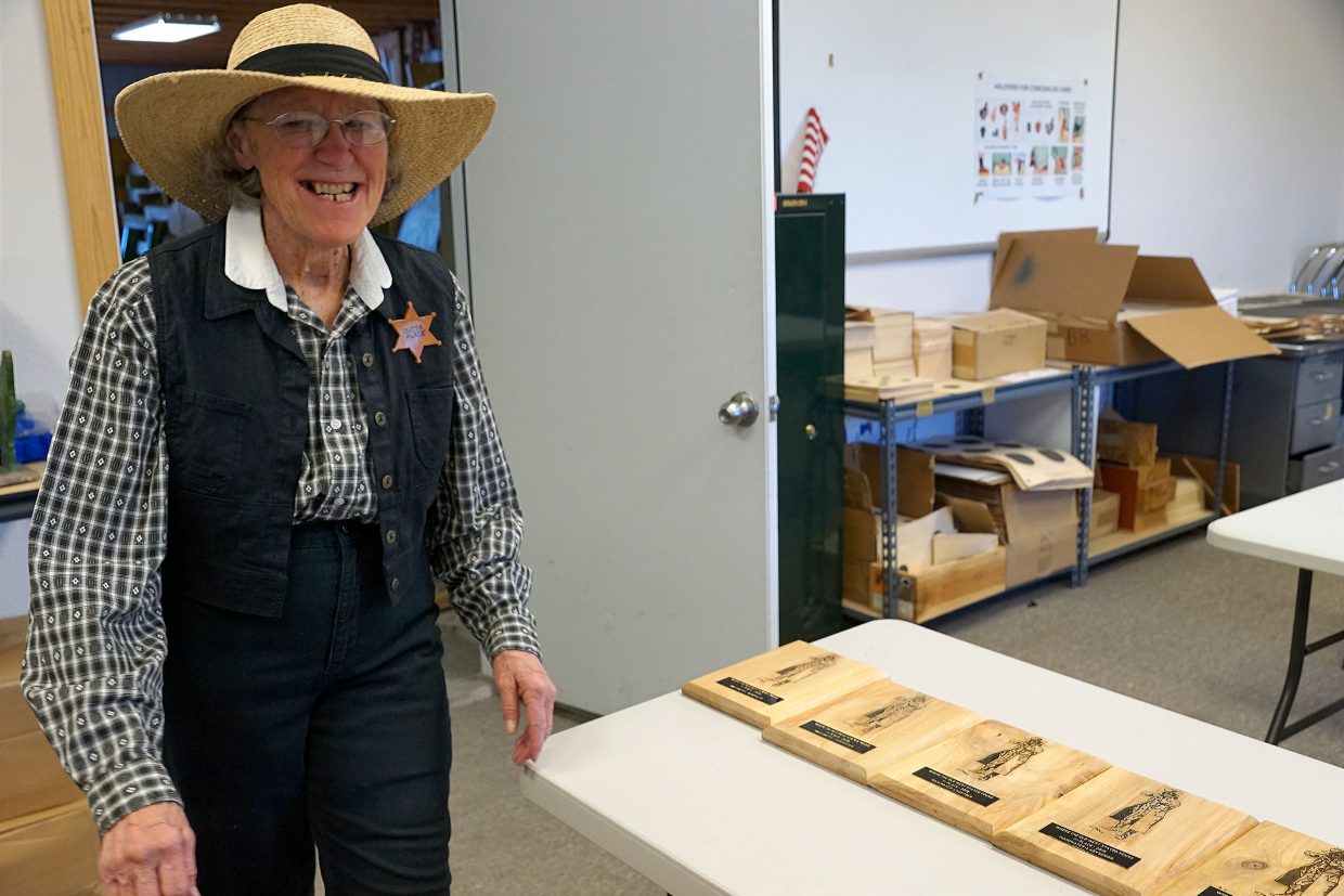 The county gal known as Outta Place smiles as she helped hand out awards to cowboy shooters Sunday.