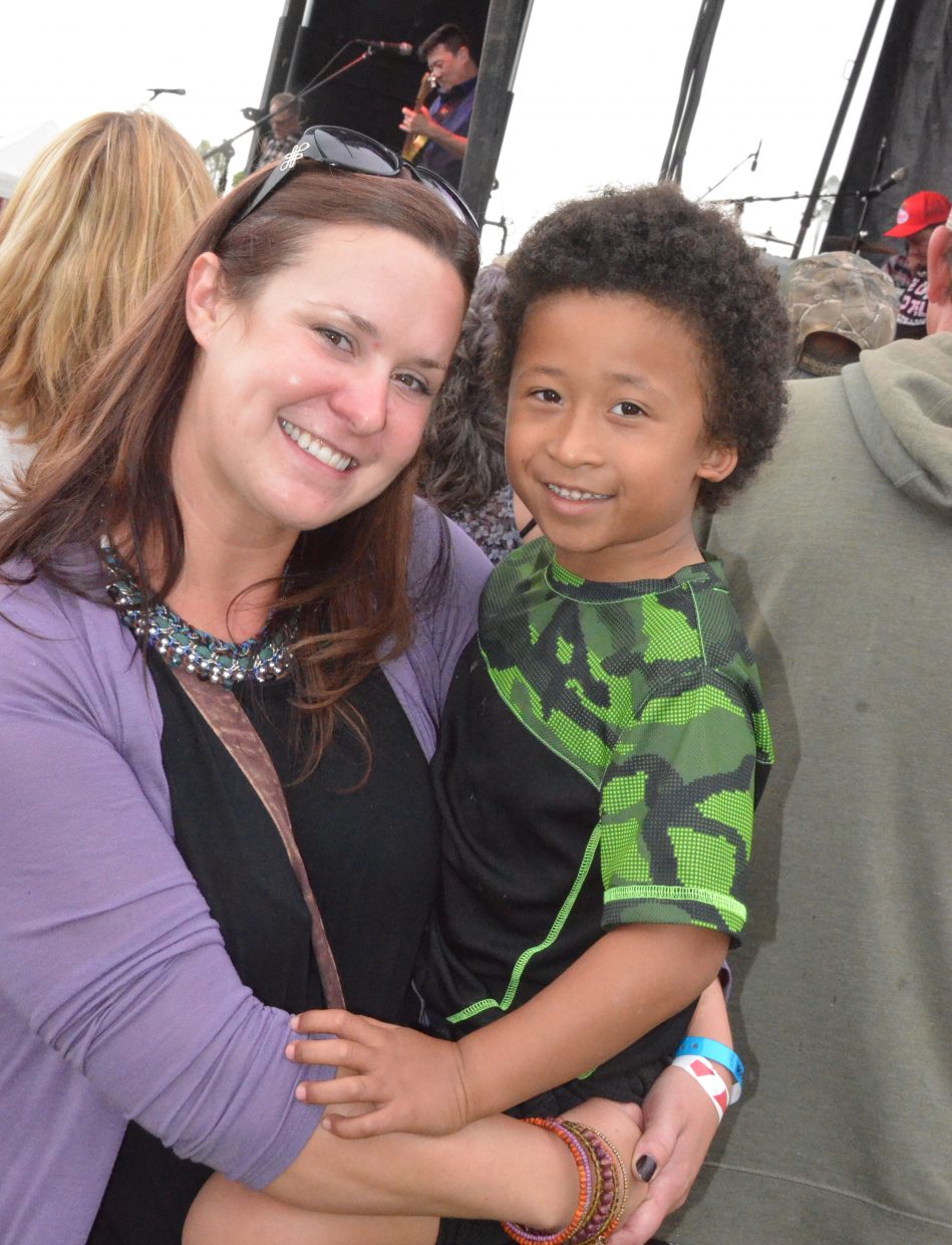 Peyton Pogline and nephew Jordan Woods smile near the front of the stage Saturday as Big Head Todd and the Monsters perform at the 19th annual Whittle the Wood Rendezvous.