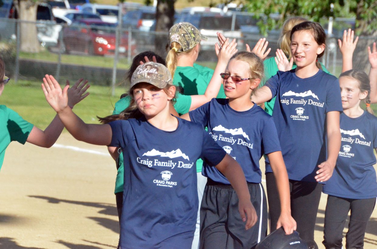 The members of Craig Family Dental exchange post-game high fives with Western American Drilling.