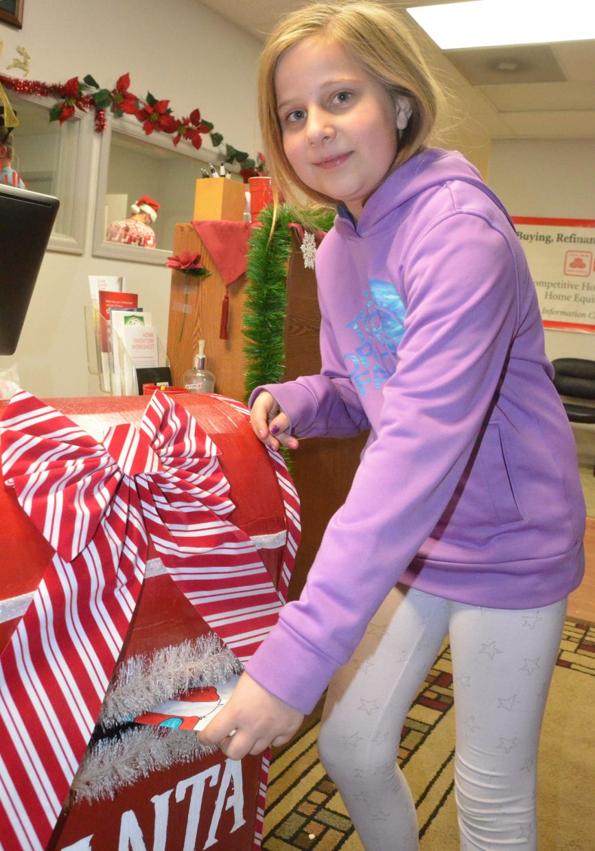 Rye Ocker drops off her letter to Santa in the specialty mailbox.