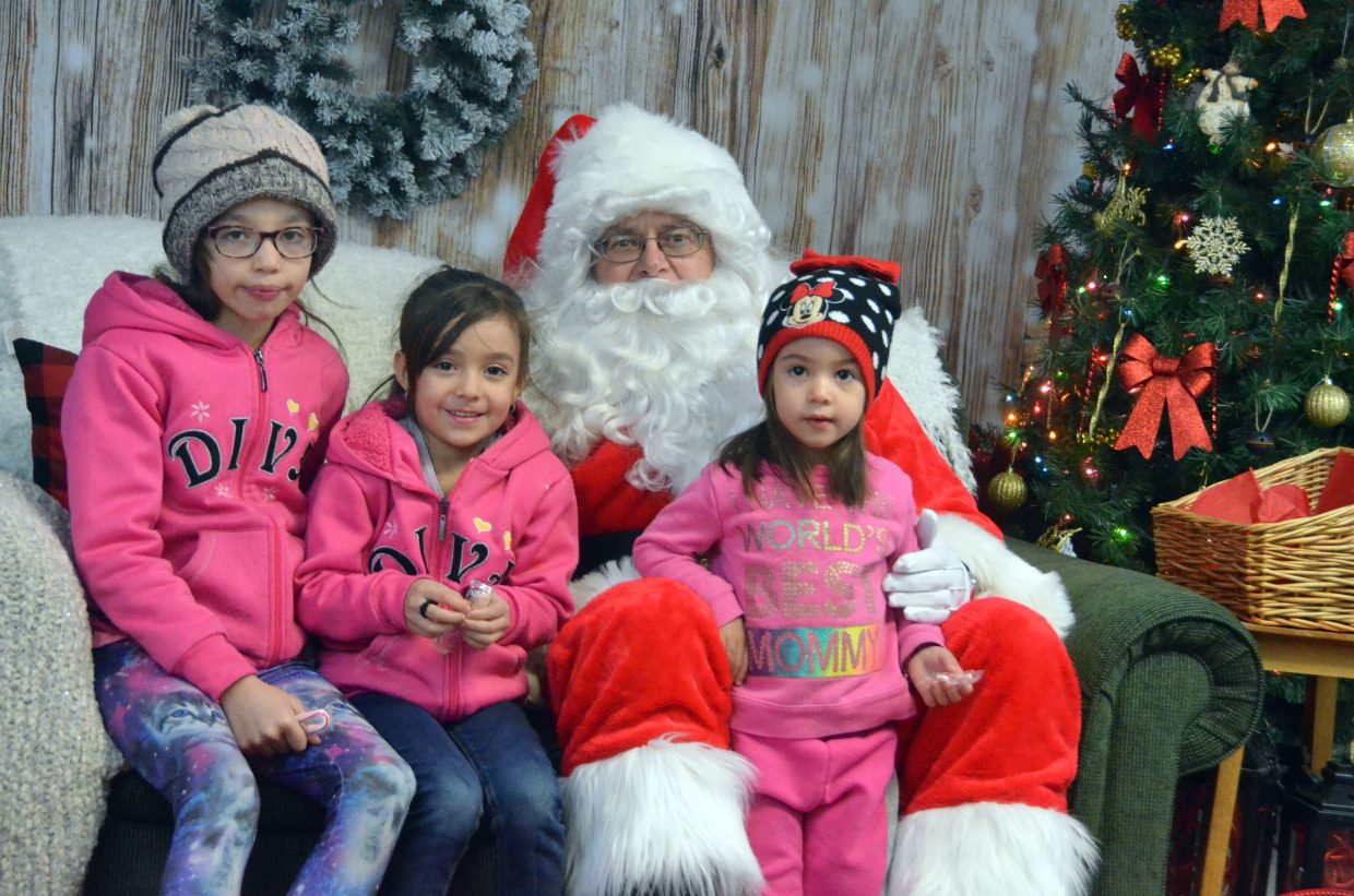 Jocelyn Quezada and siblings Arianna and Olivia pose for a photo with the big guy during Letters to Santa.