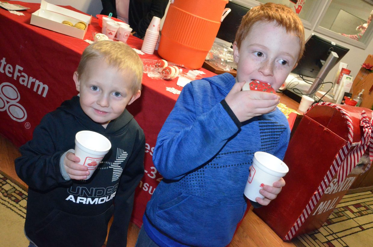 Brothers Ryker, 3, and Thane Nielson, 7, chow down on cookies and cocoa during Letters to Santa.