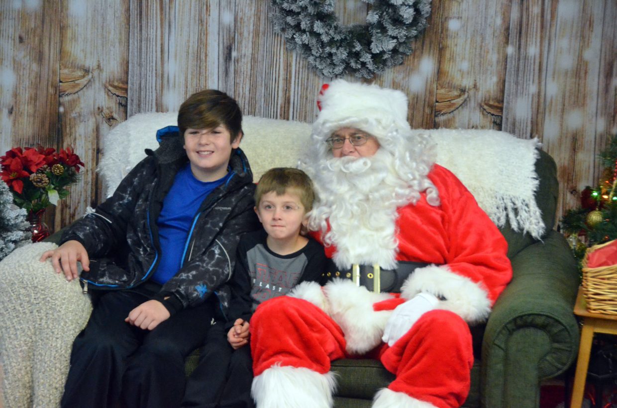 Myca, 11, and Josiah Marshall, 5, grin for the camera with Santa.
