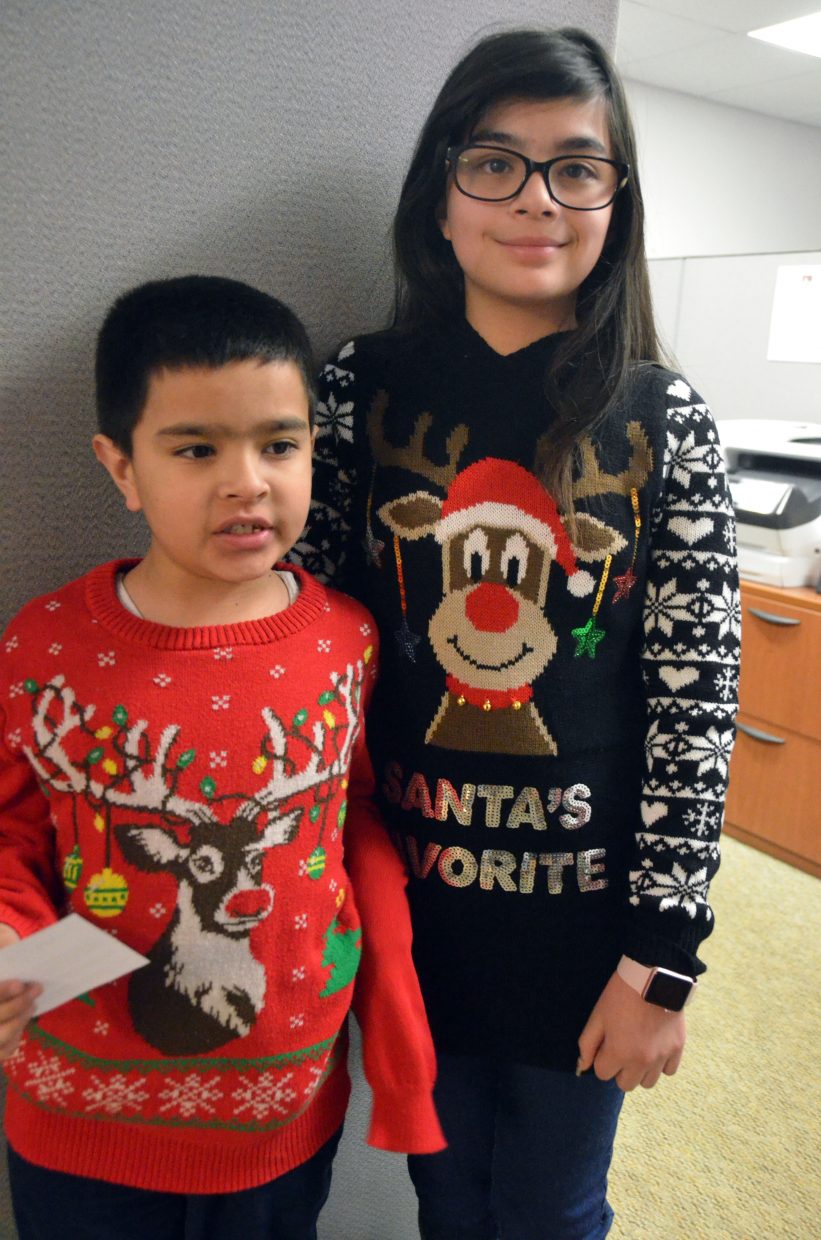 Diego, 8, and Yoselin Guevara, 11, display their holiday sweaters during Letters to Santa.