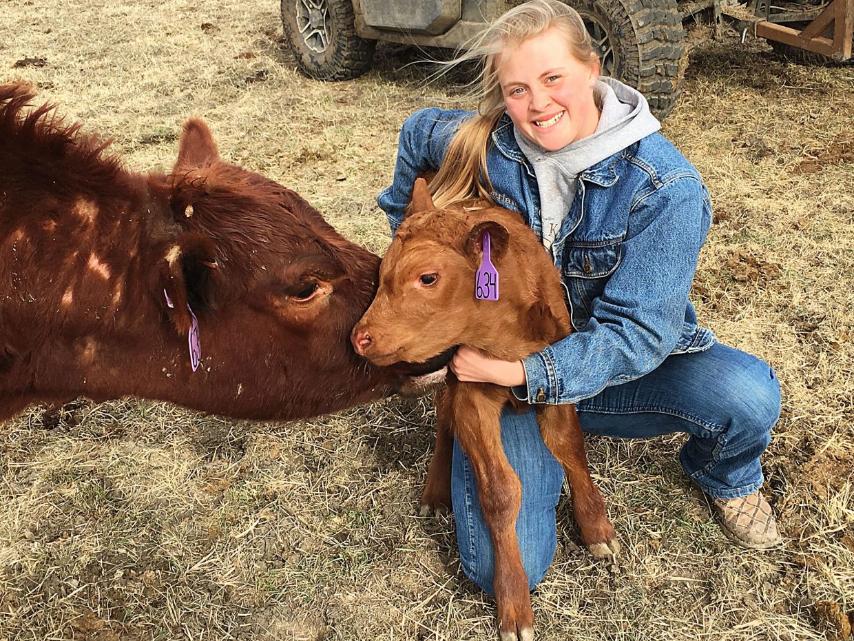 Darian Roghair and a new calf. Photo by Annalee Roghair
