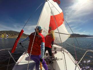 A J22 crew walks the deck to rig sails on Lake Dillon.