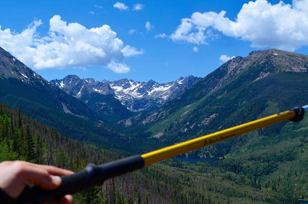 Admiring views of the Black Lake and the rest of the valley below, framed by mountain ridges of the Gore Range. The trekking pole is pointing towards the direction of where the trail would lead to next.