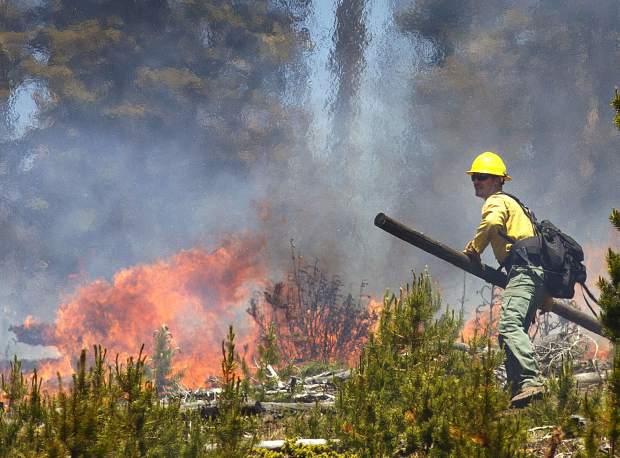 A wildland firefighter works to contain the flames at the Buffalo Fire site Wednesday, June 13, near Silverthorne.
