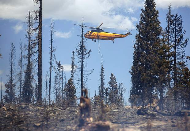 A helicopter continues to dump water on flames at the Buffalo Fire site Wednesday, June 13, near Silverthorne.
