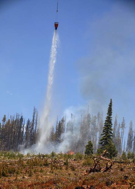 A helicopter continues to dump water on flames at the Buffalo Fire site Wednesday, June 13, near Silverthorne.