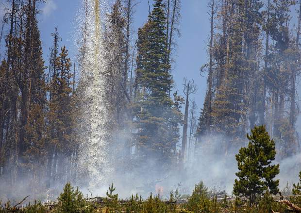 A helicopter continues to dump water on flames at the Buffalo Fire site Wednesday, June 13, near Silverthorne.