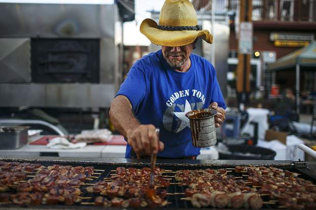 A Golden Toad cook marinates the meat at their vending spot during the Colorado BBQ Challenge on Friday, June 15, 2018, in Frisco.