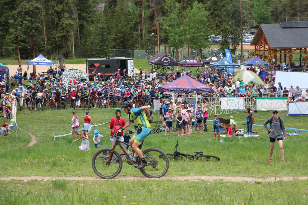 A mountain biker pedals past crowds at the Firecracker 50 mountain bike event at Carter Park in Breckenridge on Thursday.