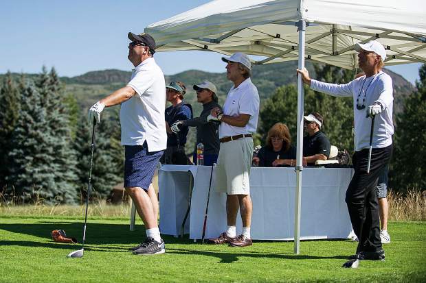 Vince Gill, left and his group watch as Bobby Bradley tees off of hole 11 at the Snowmass Club for Challenge Aspen benefit known as the Vince Gill and Amy Grant 14th Anniversary Gala and Golf Classic on Tuesday.