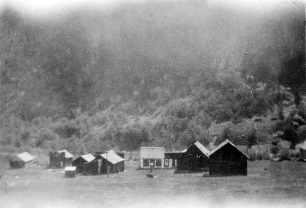 One b/w photograph showing the town of Ashcroft in 1920. Several buildings are visible, and the one with white paint is the Blue Mirror Saloon and the one across from it with a facade is the old Post Office.