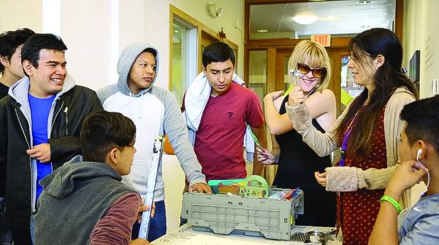 Leticia Ingram holds up various props to quiz her students on their English at the Basalt Art Base.