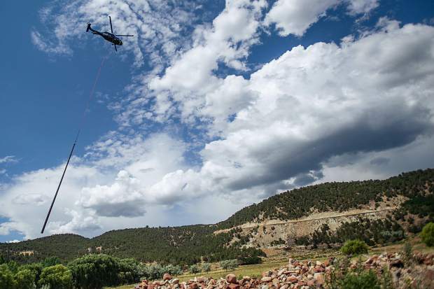A helicopter flies a telephone pole into the Lake Christine Fire burn area in El Jebel on Thursday afternoon. Electric crews flew in approximately 27 poles ranging from 3,500 pounds to 6,500 pounds.