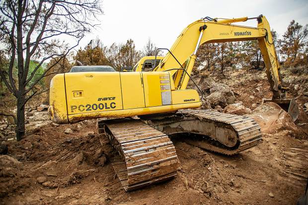 An excavator on the Lane family's property that has been used to create trenches to divert water from future flash flooding episodes on the Lake Christine burn scar on Wednesday afternoon.