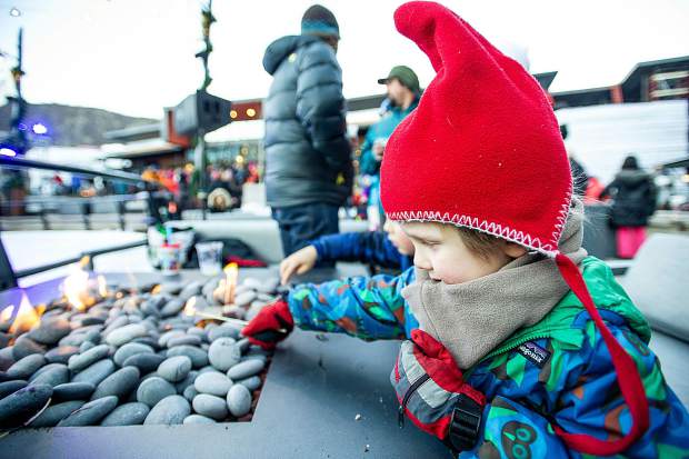 Spencer Sinclaire, 3, lights his marshmellow stick on fire in the plaza at Base Village in Snowmass on Saturday.