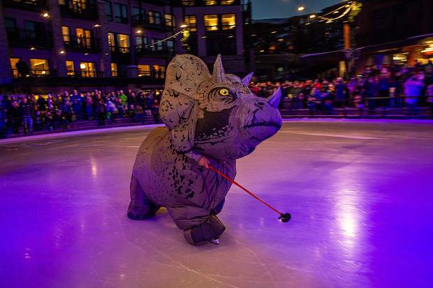 A triceratop dinosaur skates on the new ice rink at the Snowmass Base Village grand opening on Saturday.