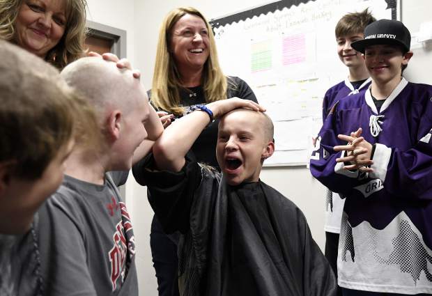 Glenwood Grizzly Bantam hockey teammates Cooper Cunningham and Hunter Oger react to seeing each other after having their heads shaved Thursday in Glenwood Springs. Cunningham’s sister Anna is battling cancer.