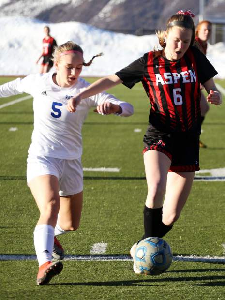 Aspen High School's Payton Curley, right, battles with Roaring Fork's Lucia Penzel duirng a girls soccer game on Tuesday, March 19, 2019, on the AHS turf. (Photo by Austin Colbert/The Aspen Times).