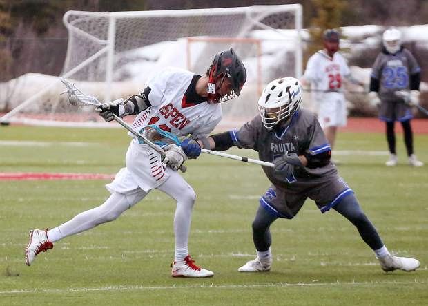 Aspen High School senior Dawson Holmes, left, goes on the attack during the boys lacrosse game against Fruita Monument on Wednesday, April 3, 2019, on the AHS turf. Fruita won, 14-9. (Photo by Austin Colbert/The Aspen Times).