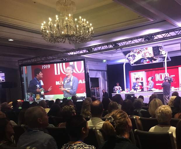 Carla Hall brings a member of the audience onstage to try one of her dishes during the Summer Soul Food seminar at St. Regis on Friday.