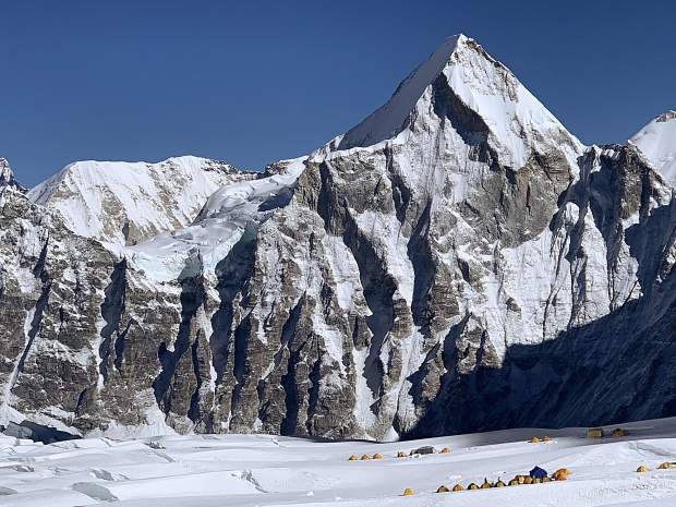 Tents rest under a high peak at Camp II.