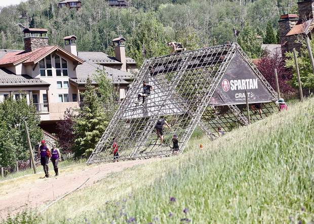 Athletes climb the A-frame cargo net on Saturday, Aug. 3, 2019, during the first-ever Spartan obstacle-course race in Snowmass. (Photo by Austin Colbert/The Aspen Times)