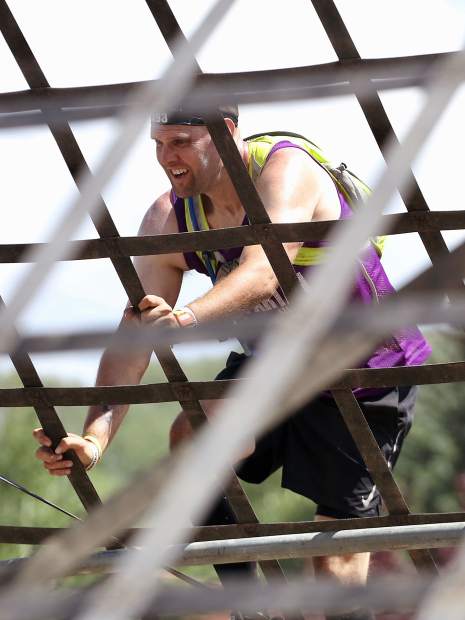 An athlete climbs the A-frame cargo net on Saturday, Aug. 3, 2019, during the first-ever Spartan obstacle-course race in Snowmass. (Photo by Austin Colbert/The Aspen Times)