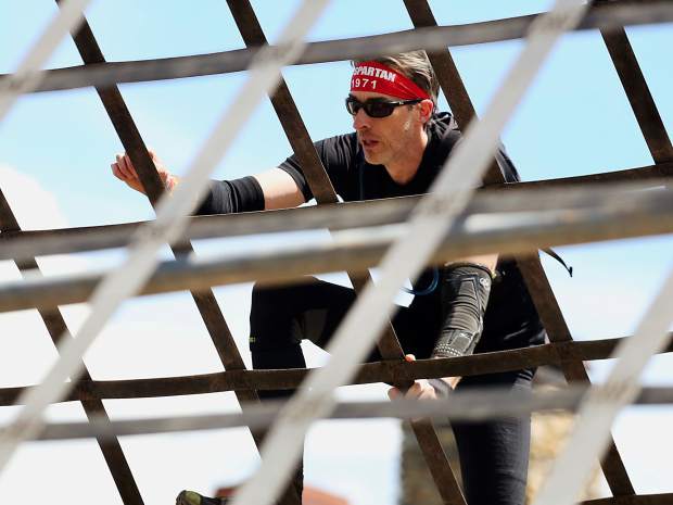 An athlete climbs the A-frame cargo net on Saturday, Aug. 3, 2019, during the first-ever Spartan obstacle-course race in Snowmass. (Photo by Austin Colbert/The Aspen Times)