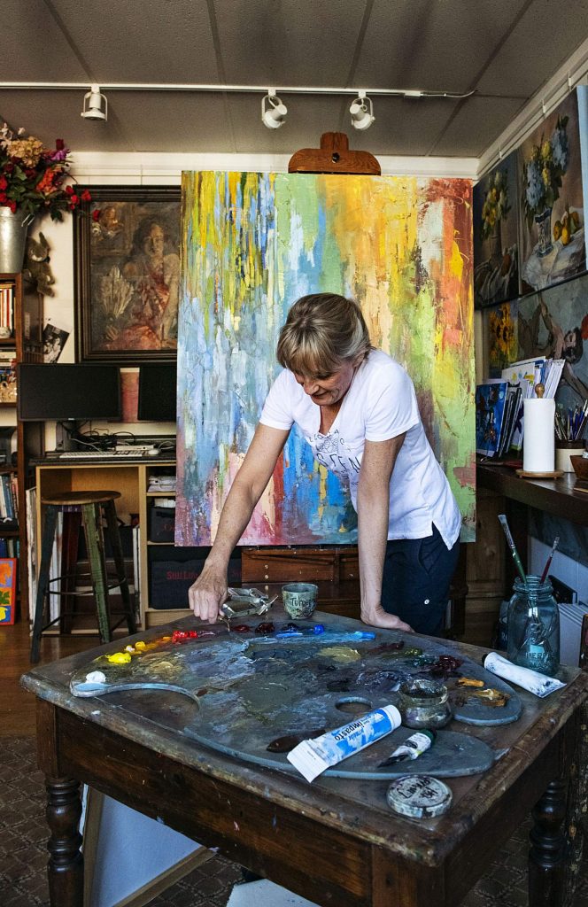 Lorraine Davis mixes oil paint to add to her large canvas in her studio at the Red Brick Center for the Arts in Aspen on Thursday, November 14, 2019. Davis created the piece using a palette knife, which she said was unusual for her. Davis’s oil paintings explore everything from abstract to realism. She’s been a resident at the Red Brick since 2013. (Kelsey Brunner/The Aspen Times)