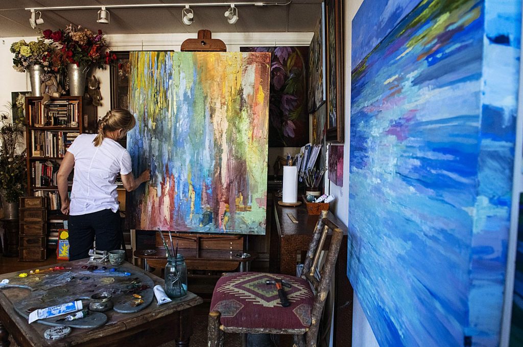 Lorraine Davis adds oil paint to her large canvas in her studio at the Red Brick Center for the Arts in Aspen on Thursday, November 14, 2019. Davis said she had been working on the piece for some time. (Kelsey Brunner/The Aspen Times)