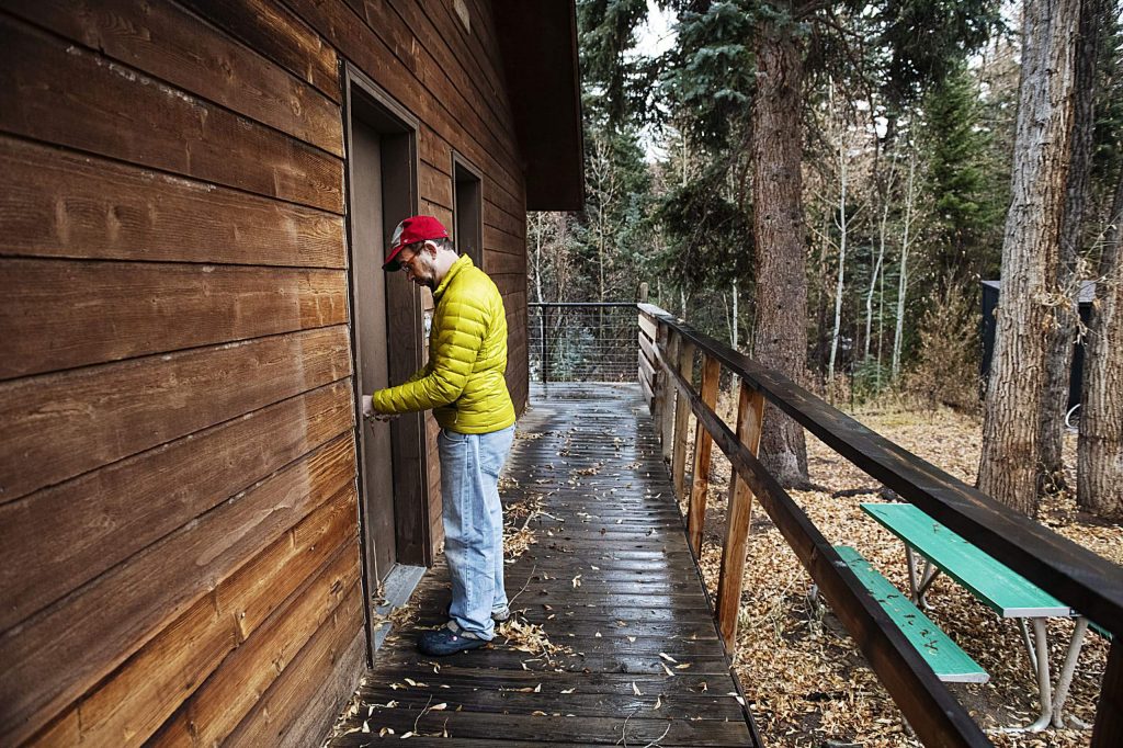 Eric Kaika unlocks the door to one of the many rooms available to campers on the Aspen Camp property in Old Snowmass on Thursday, Nov. 21, 2019. (Kelsey Brunner/The Aspen Times)