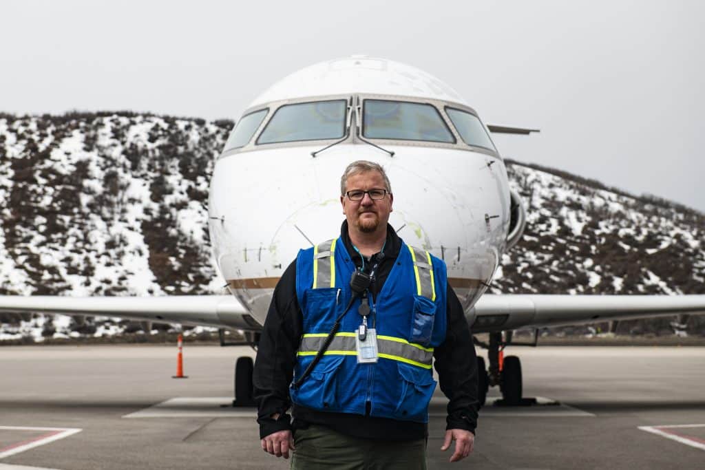 Aspen/Pitkin County Airport senior operations security coordinator Adam Gardner stands on the ramp on Thursday, April 2, 2020. Gardner has been with the Aspen Airport for three years. He went to University of North Dakota and graduated right before 9/11. “Everybody who is an essential worker, we’re all doing our best to limit our exposure and go a step further to ensure the safety of our passengers,” said Gardner. 