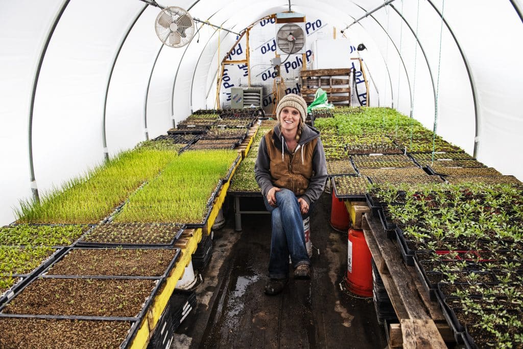 Two Roots Farm’s Harper Kaufman sits in her greenhouse in Basalt on Thursday, April 2, 2020. 